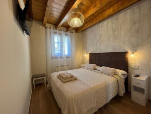 a bedroom with a large bed with a white blanket at Apartamentos Miguel 2 in Onís