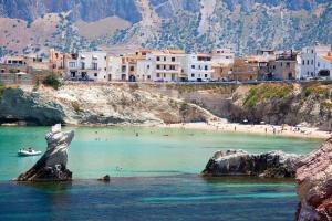 a view of a beach with a statue in the water at La Casa di Mariano in Terrasini
