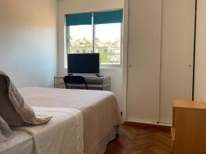 a bedroom with a bed and a desk with a computer at Hostal Recreo in Viña del Mar
