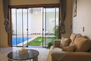 a living room with a couch and a glass table at Farida Palace Hotel in Al Aqālitah