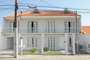 a white house with a fence in front of it at Pousada Fernanda in Guarapuava
