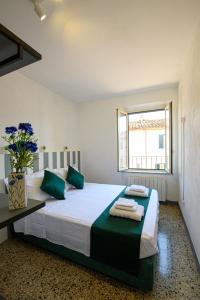 a bedroom with a large bed with green pillows at Dimora l'Arancio in Lucca