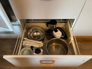 a drawer filled with pots and pans and other kitchen utensils at Ferienwohnung Darosa Alpenliebe in Seeg +7 photos