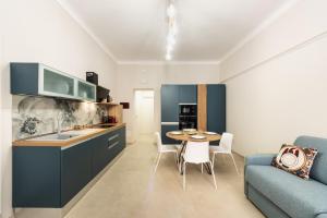 a kitchen and living room with a table and a couch at Casa Amarantia-Appartamento 2 in Noto +9 photos