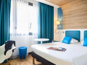 a hotel room with a bed and a chair at ibis Styles Montelimar Centre in Montélimar +57 photos