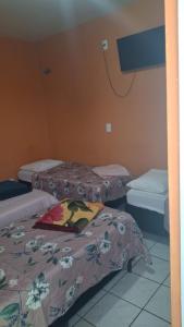 a room with three beds in a room at Pousada Sevilha in Sumaré +2 photos