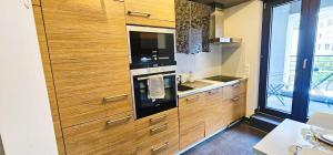 a kitchen with wooden cabinets and an oven at Central Luxembourg Stay-2BR in Hollerich