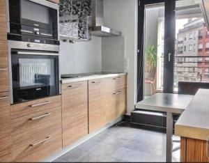 a kitchen with wooden cabinets and a stove top oven at Central Luxembourg Stay-2BR in Hollerich
