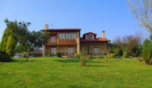 a large house on a grassy field in front at Casa Torreteyera in Villaviciosa