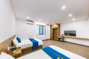 a hotel room with a bed and a flat screen tv at KEY'N'S HOUSE FLC Sầm Sơn in Sầm Sơn