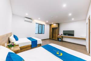 a hotel room with two beds and a flat screen tv at KEY'N'S HOUSE FLC Sầm Sơn in Sầm Sơn