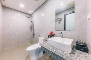 a bathroom with a sink and a toilet and a mirror at KEY'N'S HOUSE FLC Sầm Sơn in Sầm Sơn +18 photos
