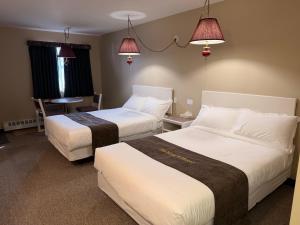 a hotel room with two beds and a table at The King's Motel in Sundre