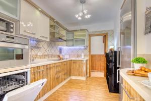 a kitchen with wooden cabinets and stainless steel appliances at 4BR Wellness Villa- Pool, Sauna, Gym in Puerto de la Cruz
