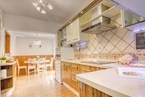 a kitchen with wooden cabinets and a table with chairs at 4BR Wellness Villa- Pool, Sauna, Gym in Puerto de la Cruz +36 photos