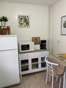 a kitchen with a white refrigerator and a microwave at Las Tres Luces Casa 1 in Llanes