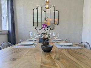 a dining room with a wooden table with a chandelier at Le St Mens in Gap