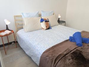 a bedroom with a bed with blue sheets and pillows at Le St Mens in Gap