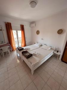 a bedroom with a large white bed in a room at Joanna Rooms in Skala Eresou +64 photos