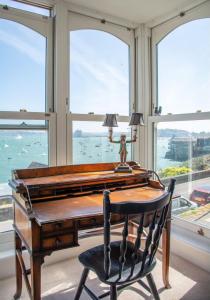 an office with a desk and a chair and windows at An Glas Bras - By Rowes Retreats in Falmouth +148 photos