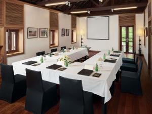 a large meeting room with white tables and black chairs at Sofitel Luang Prabang in Luang Prabang +137 photos