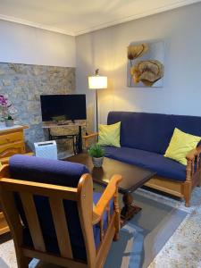 a living room with a blue couch and a table at Las Tres Luces Casa 1 in Llanes