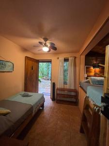 a bedroom with two beds and a ceiling fan at Tico Adventure Lodge in Sámara