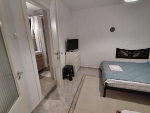 a small bedroom with a bed and a television at Trikeri pleasant stay in Ayía Kiriakí