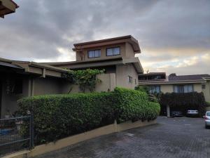 a house with a hedge in front of a building at San Remo 1 in San Pedro