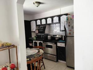 a kitchen with stainless steel appliances and a table at San Remo 1 in San Pedro