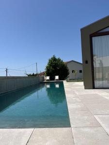 a swimming pool in front of a house at Dovecote Houses in Viana do Castelo
