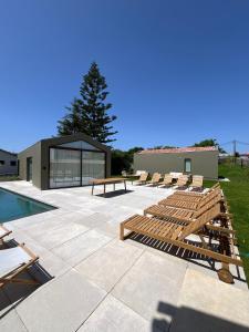 a patio with lounge chairs and a swimming pool at Dovecote Houses in Viana do Castelo