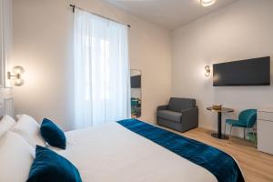 a bedroom with a large bed and a chair at Aethel Guesthouse in Rome