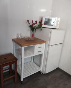 a small table with a vase of flowers on top of a refrigerator at Sonnenhaus Leo Hutthurm in Hutthurm