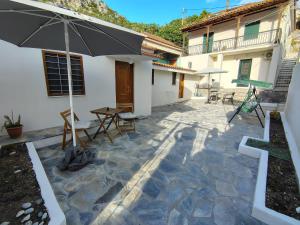 a patio with an umbrella and tables and chairs at Trikeri Pleasant Stay2 in Trikeri