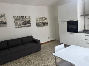 a living room with a black couch and a kitchen at Casa Limmy in Intra