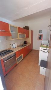 a kitchen with orange cabinets and a sink and a stove at Casa Sofia in Torre delle Stelle