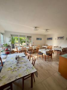 a dining room with tables and chairs and windows at Pension Kiwi in Mikulov