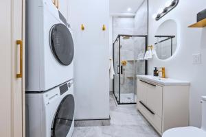 a bathroom with a washer and dryer next to a shower at Casa Hotels Gerrard Newly Built Suite Steps to Transit in Toronto