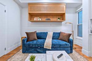 a blue couch in a living room with a table at Casa Hotels Gerrard Newly Built Suite Steps to Transit in Toronto +13 photos