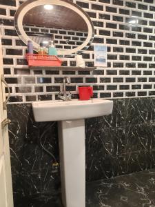 a bathroom with a sink and a mirror at Nizel Inn in Darjeeling