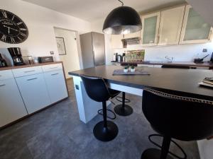 a kitchen with a counter and a large clock on the wall at Ferienwohnung am See Dillich - Schwimmteich - Eigener Garten - Ruhige Lage - Hunde willkommen in Borken