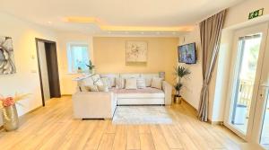 a living room with a white couch and wooden floors at Istrian Lux Residence by Istrian apartments Koper in Koper