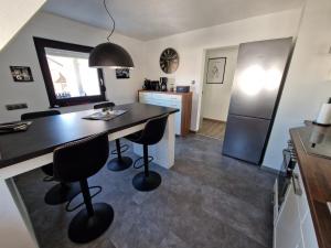 a kitchen with a table and chairs and a refrigerator at Ferienwohnung am See Dillich - Schwimmteich - Eigener Garten - Ruhige Lage - Hunde willkommen in Borken +28 photos