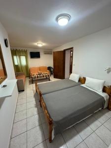 a bedroom with two beds and a living room at Joanna Rooms in Skala Eresou