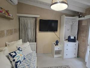 a bedroom with a bed and a tv on the wall at LA PIGNA BLU CasaVacanza con Piscina in Botrugno