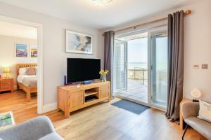 a living room with a television and a sliding glass door at 2 Bed in Torcross oc-bcatbe in Torcross