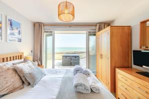 a bedroom with a bed with towels and a television at 2 Bed in Torcross oc-bcatbe in Torcross