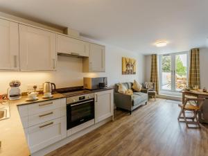 a kitchen with white cabinets and a living room at 2 Bed in Brockenhurst oc-78729 in Brockenhurst