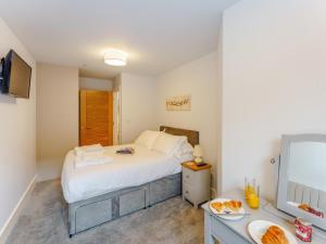 a bedroom with a bed and a desk with a television at 2 Bed in Brockenhurst oc-78729 in Brockenhurst